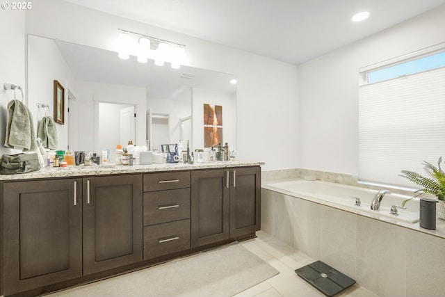 bathroom with vanity, tile patterned flooring, and tiled bath