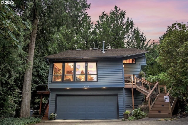 view of front of home featuring stairway, an attached garage, and driveway