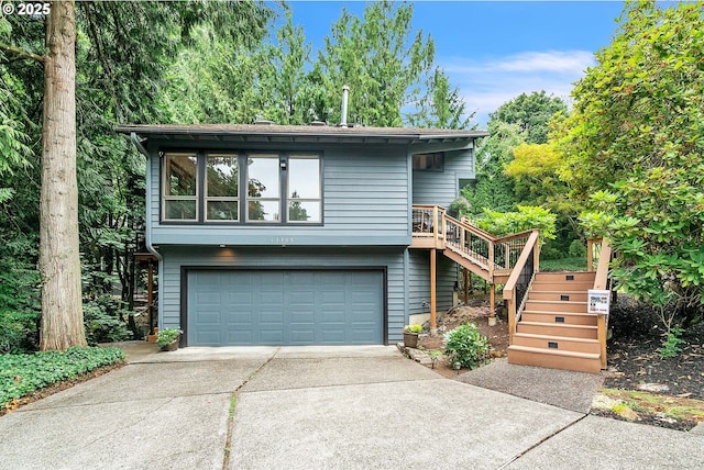 view of front of home with stairway, an attached garage, and driveway