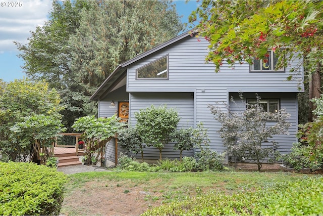 view of side of home featuring a lawn and a deck