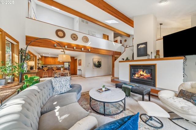 13305 Fox Run, Lake Oswego, OR 97034 - carpeted living area with a glass covered fireplace, beamed ceiling, and a high ceiling