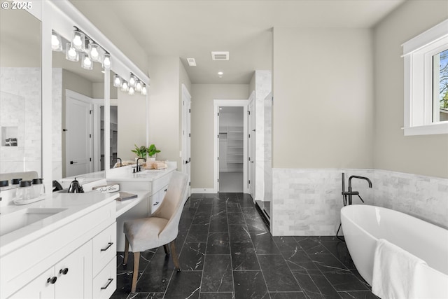 15007 Twin Fir Rd, Lake Oswego, OR 97035 - full bathroom featuring two vanities, tile walls, a freestanding tub, wainscoting, and marble look tiles