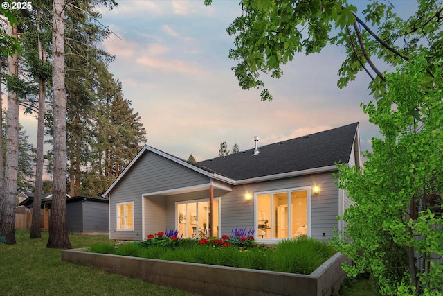 15007 Twin Fir Rd, Lake Oswego, OR 97035 - back of property at dusk featuring roof with shingles and a lawn