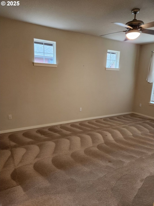 carpeted empty room with a wealth of natural light and ceiling fan