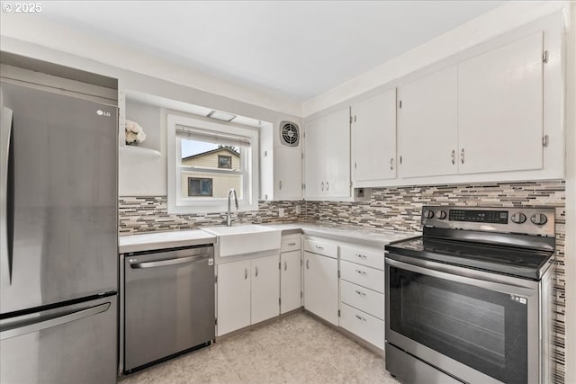 4004 SE 97th, Portland, OR 97266 - kitchen featuring stainless steel appliances, light countertops, decorative backsplash, a sink, and white cabinetry