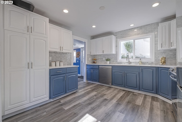 1060 SW 206th Ave, Beaverton, OR 97003 - kitchen featuring stainless steel dishwasher, a sink, tasteful backsplash, blue cabinets, and light wood finished floors