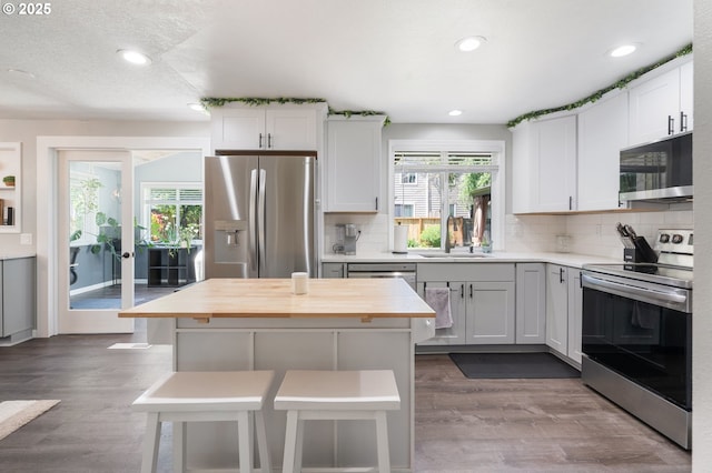 3141 SW 176th Ave, Beaverton, OR 97003 - kitchen featuring stainless steel appliances, wood counters, healthy amount of natural light, wood finished floors, and recessed lighting
