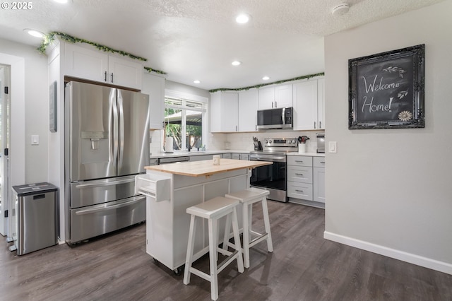 3141 SW 176th Ave, Beaverton, OR 97003 - kitchen featuring stainless steel appliances, dark wood-type flooring, wood counters, white cabinetry, and a center island