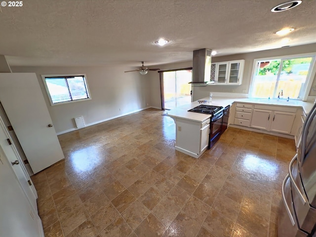3880 SW 194th Pl, Beaverton, OR 97078 - kitchen with island range hood, black gas stove, white cabinetry, a textured ceiling, and a peninsula