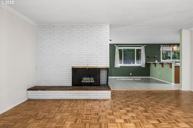 3985 Donald St, Eugene, OR 97405 - unfurnished living room with baseboards, a brick fireplace, ornamental molding, and a textured ceiling