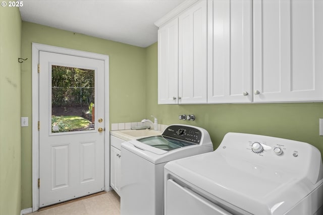 3985 Donald St, Eugene, OR 97405 - laundry area featuring washing machine and clothes dryer, cabinet space, and light tile patterned floors