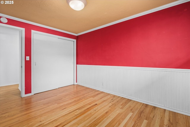 3985 Donald St, Eugene, OR 97405 - unfurnished bedroom with wood finished floors, wainscoting, a closet, and crown molding