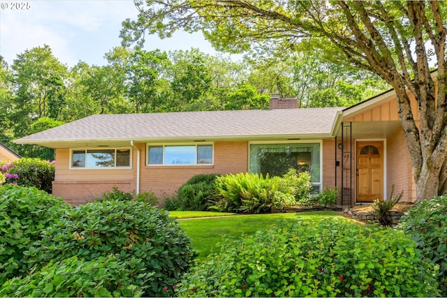 3985 Donald St, Eugene, OR 97405 - ranch-style house featuring brick siding, a chimney, roof with shingles, and a front lawn