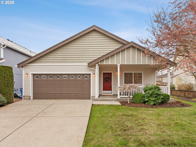 view of front of property featuring a porch, driveway, a front lawn, and an attached garage
