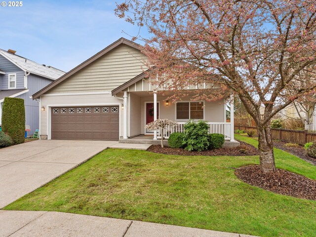 traditional-style house with concrete driveway, fence, a front lawn, a porch, and a garage