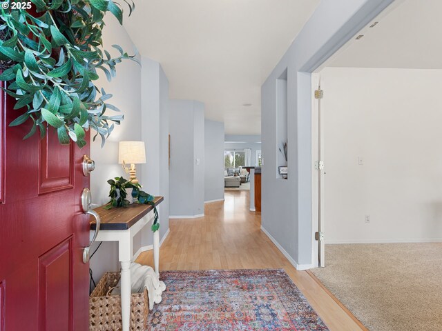 foyer featuring light wood-style flooring and baseboards