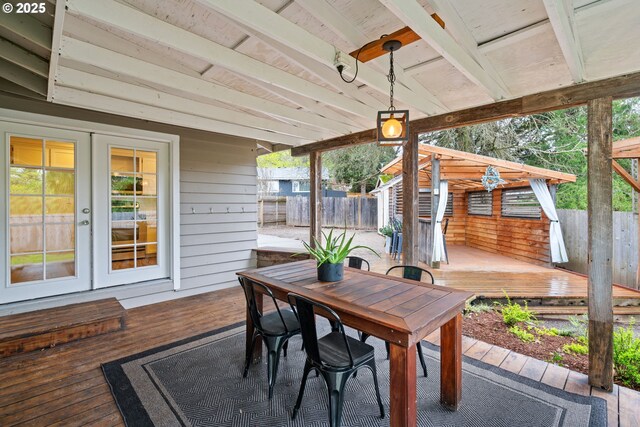 deck featuring outdoor dining area, fence, and french doors
