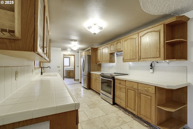 4805 NE 122nd Ave, Vancouver, WA 98682 - kitchen featuring stainless steel appliances, open shelves, a sink, decorative backsplash, and a textured ceiling