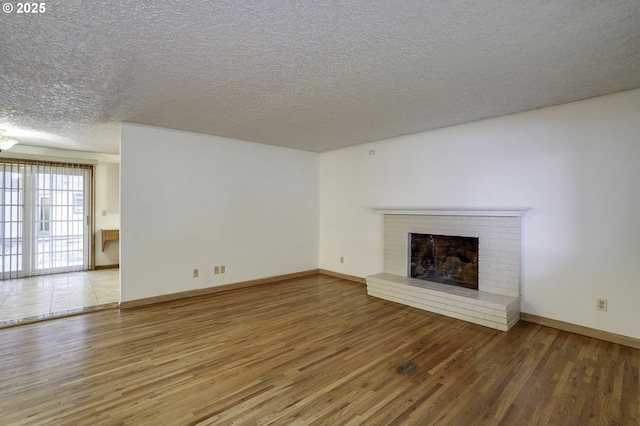 4805 NE 122nd Ave, Vancouver, WA 98682 - unfurnished living room featuring wood finished floors, a fireplace, a textured ceiling, and baseboards