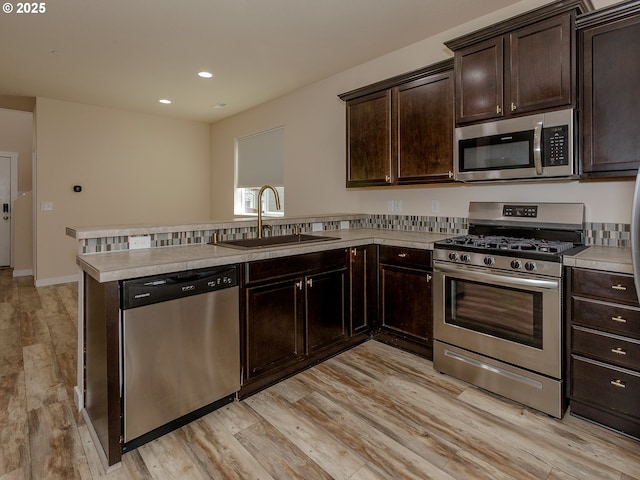 7417 N 92nd Ave, Camas, WA 98607 - kitchen featuring appliances with stainless steel finishes, light wood-type flooring, light countertops, dark brown cabinets, and recessed lighting