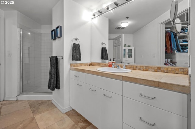 full bathroom featuring a shower stall, vanity, and tile patterned flooring