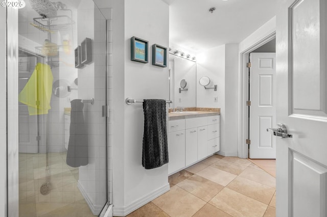 bathroom featuring a stall shower, vanity, tile patterned floors, and baseboards
