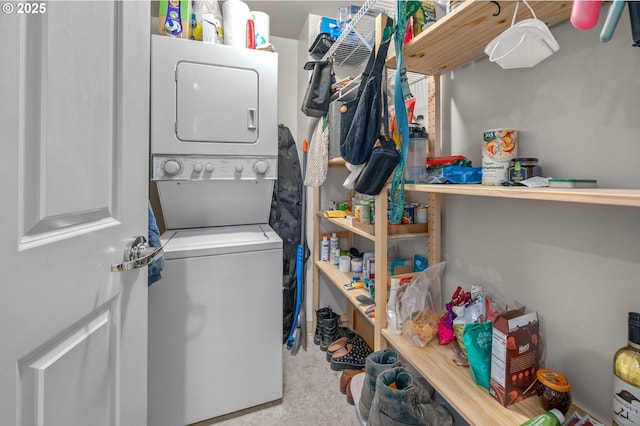 laundry area featuring stacked washer / drying machine and carpet flooring