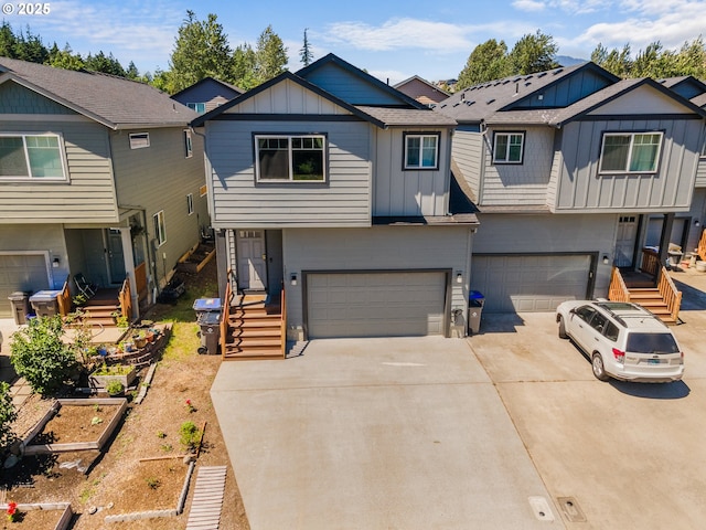 1233 SE Windsong Dr, Cascade Locks, OR 97014 - view of front of property with board and batten siding, an attached garage, a garden, and concrete driveway