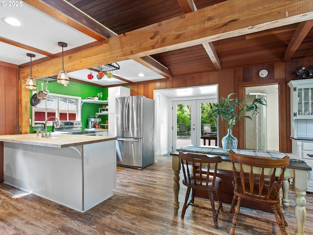 kitchen featuring a sink, stainless steel appliances, beam ceiling, and wood finished floors