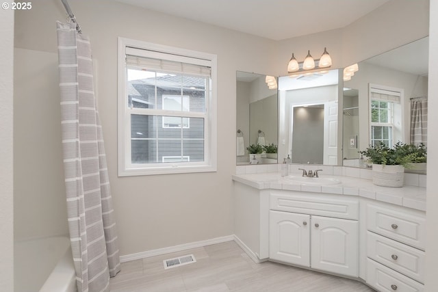 full bathroom with visible vents, vanity, and baseboards