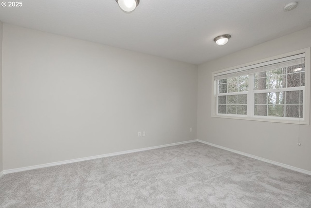 unfurnished room with baseboards and carpet floors