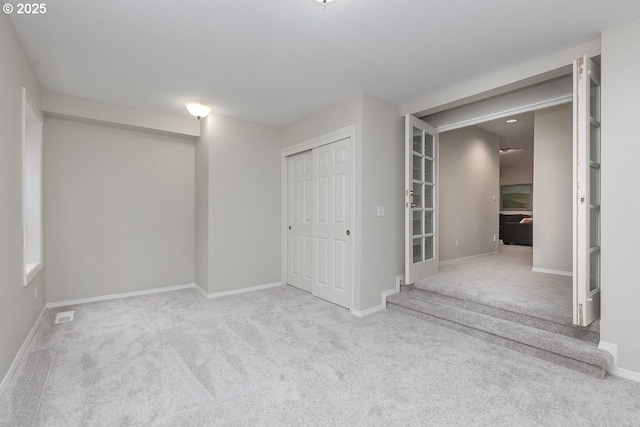 interior space with a closet, baseboards, carpet, and visible vents