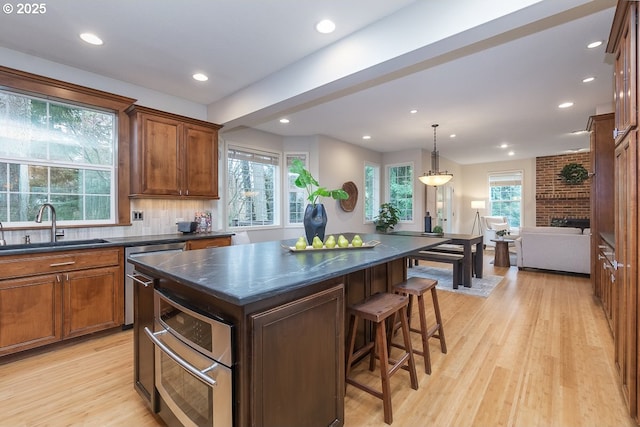 kitchen featuring dark countertops, light wood-style flooring, and a sink