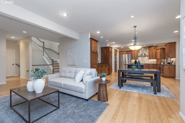 living area with recessed lighting, stairway, and light wood-style flooring