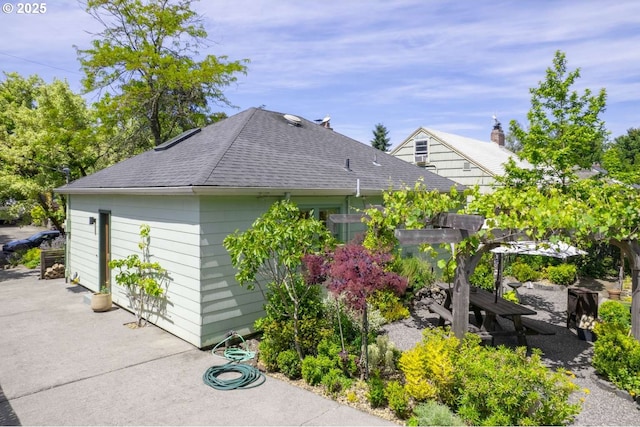 6814 N Wall Ave, Portland, OR 97203 - view of side of home featuring roof with shingles and a patio