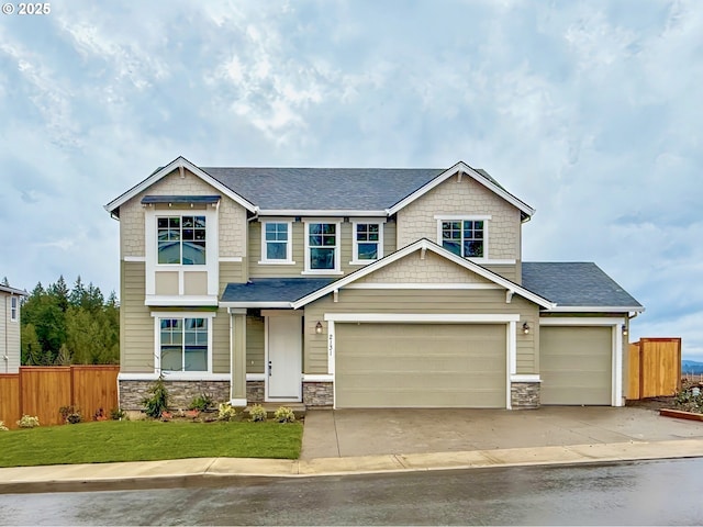 craftsman-style home featuring driveway, stone siding, fence, a front yard, and an attached garage