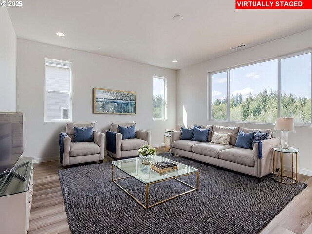 living room with recessed lighting, baseboards, visible vents, and light wood-style flooring
