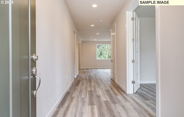 hallway featuring recessed lighting, baseboards, and light wood-style floors