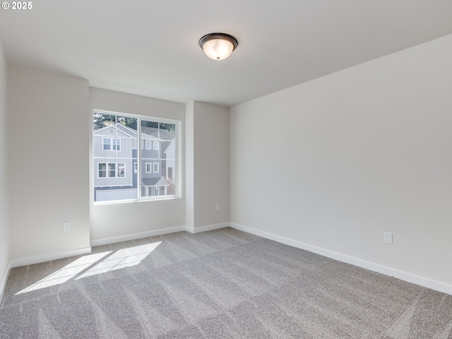 carpeted empty room with baseboards