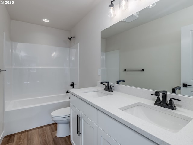 bathroom featuring toilet, shower / bath combination, a sink, and wood finished floors