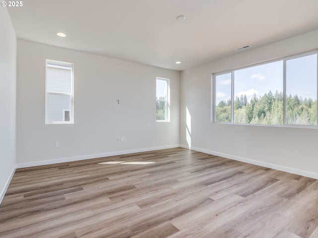 unfurnished room featuring light wood-style floors, recessed lighting, baseboards, and visible vents