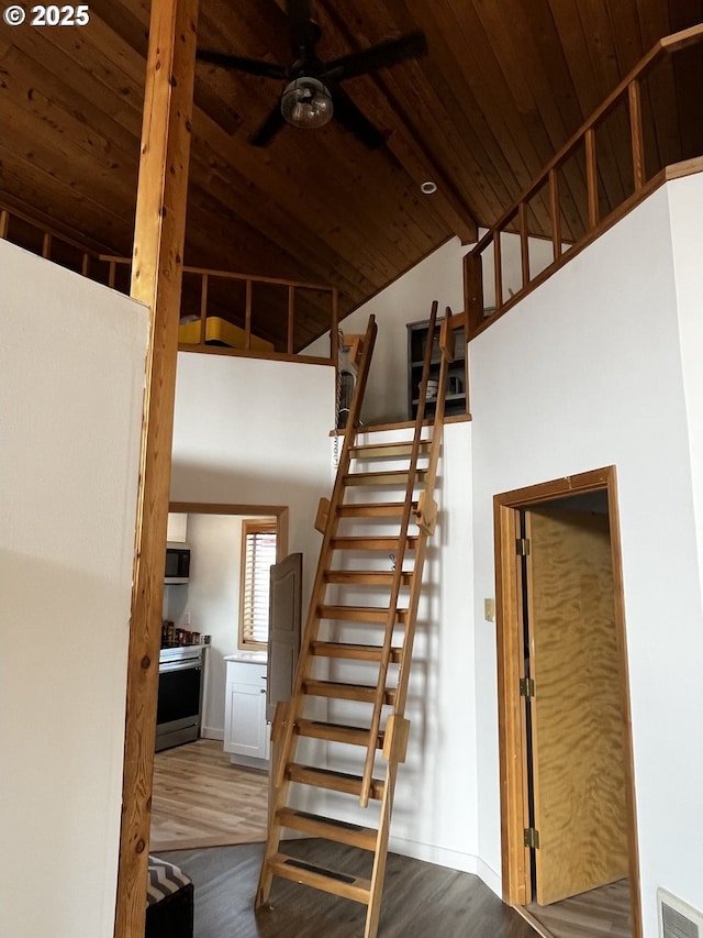 stairs featuring visible vents, a ceiling fan, wood ceiling, wood finished floors, and high vaulted ceiling