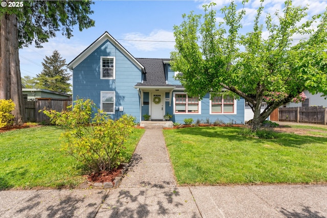 view of front of property with fence, roof with shingles, and a front yard