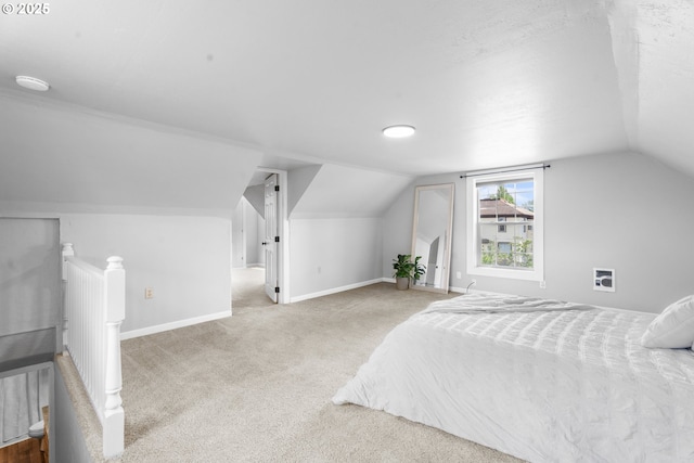 carpeted bedroom featuring baseboards and vaulted ceiling