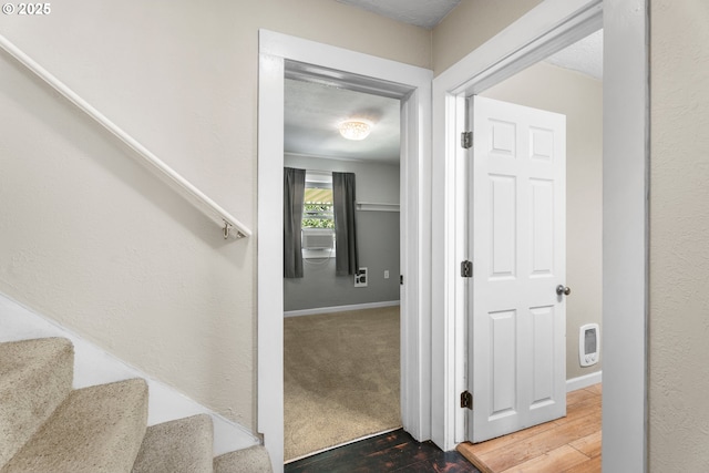 staircase featuring baseboards and wood finished floors