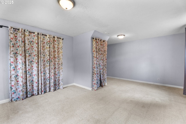 unfurnished room with carpet floors and baseboards