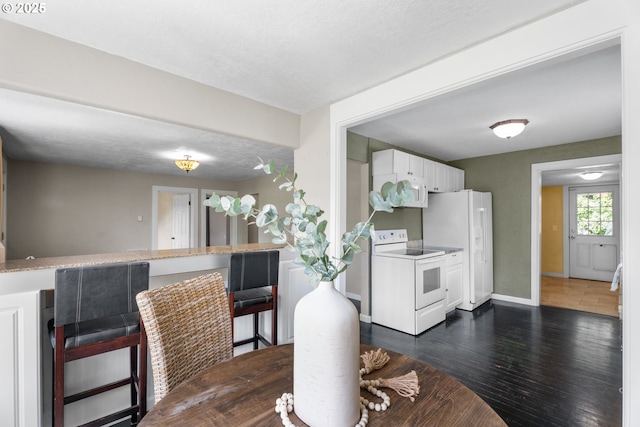 dining area featuring baseboards and dark wood-style floors