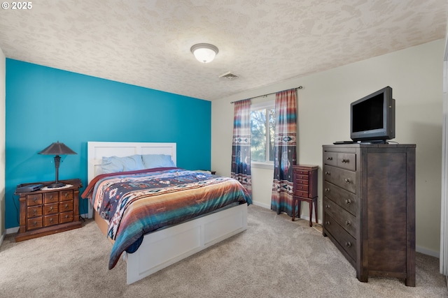 bedroom featuring a textured ceiling and light carpet