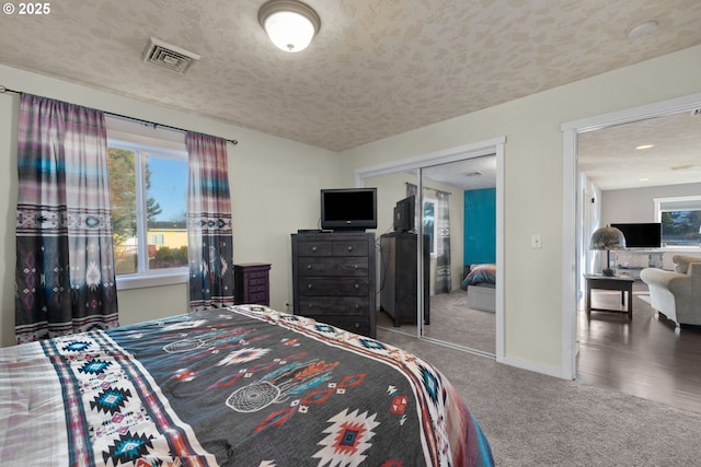 bedroom with a closet, carpet, and a textured ceiling