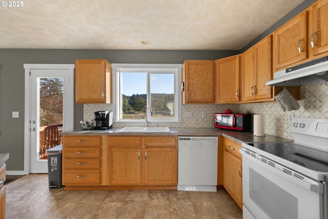 kitchen featuring sink, white appliances, decorative backsplash, and a wealth of natural light